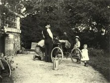 V7309-Entretien du tricycle par Louis, à gauche les enfants Jean et Suzanne, en melon, peut-être Georges Bidel